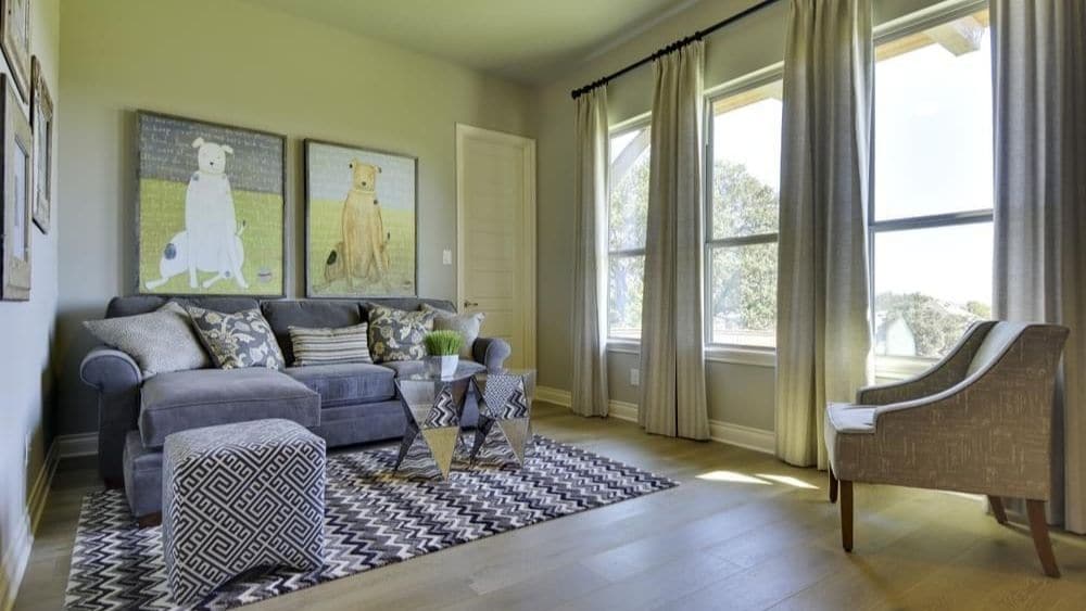 A small living room with windows letting in a lot of sunlight.