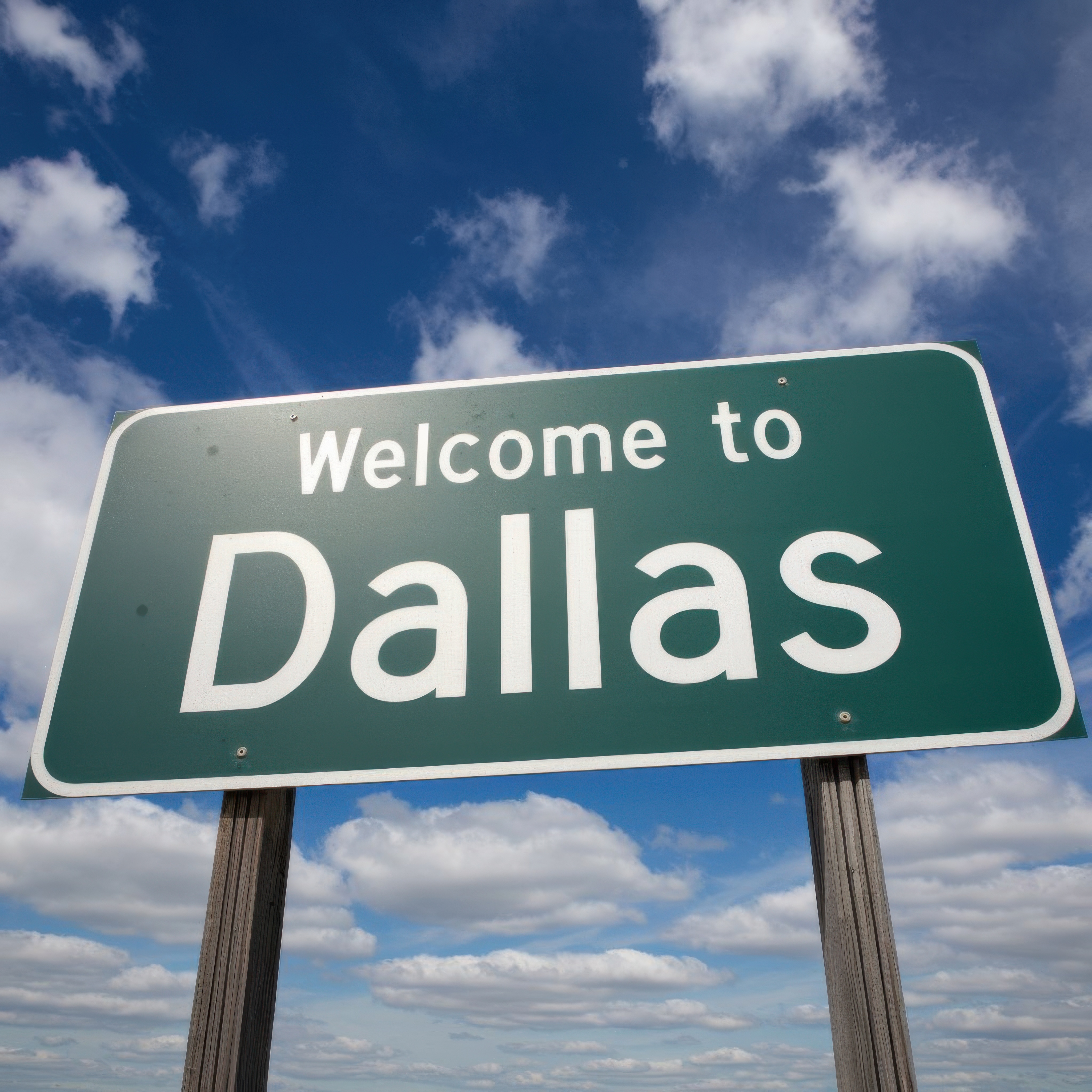 Welcome to Dallas green road sign with a sunny blue sky background
