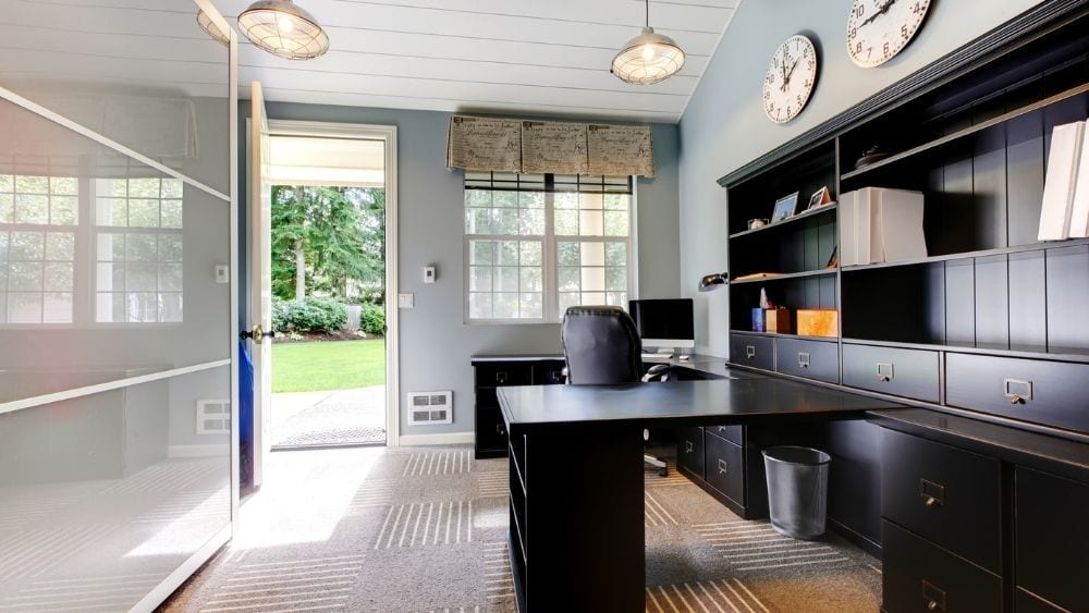 Shelving and cabinets on a wall bisected by an attached desk.
