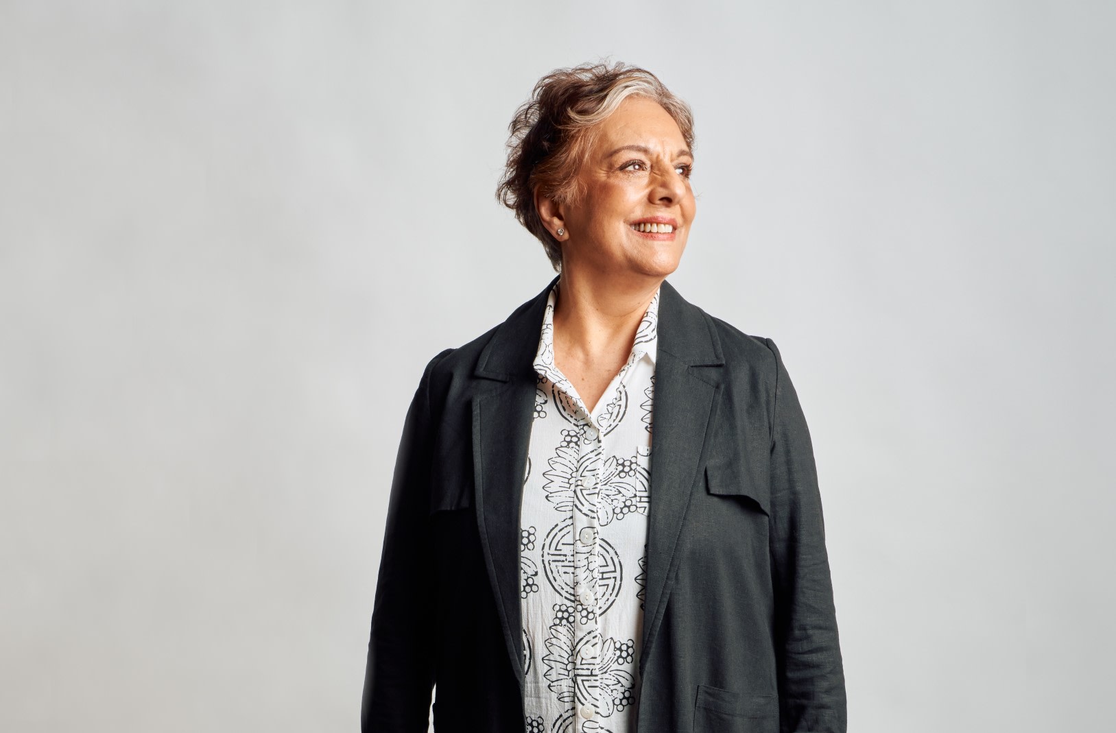 Woman in white shirt and black jacket smiling