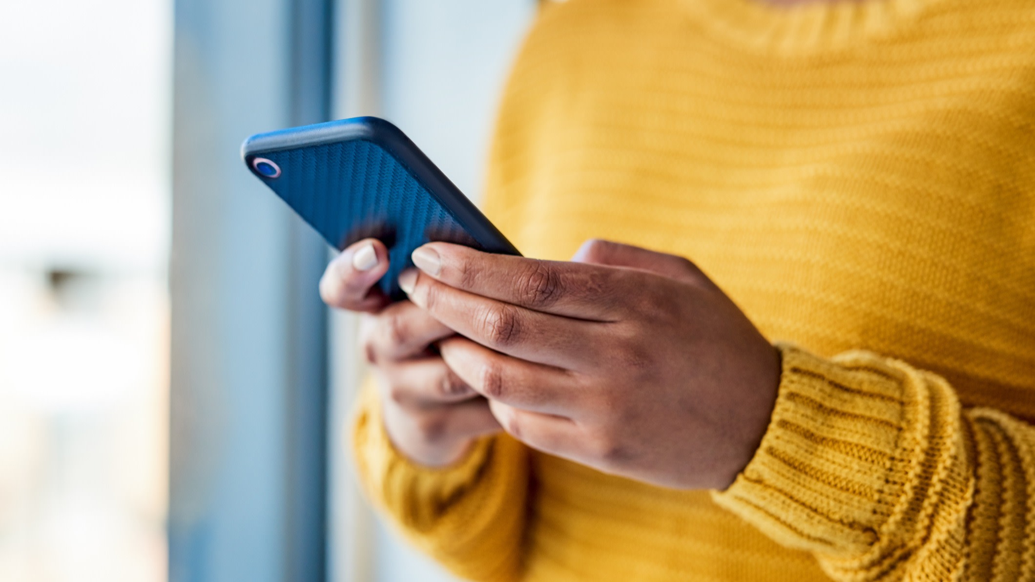 Shot of an unrecognizable woman using a mobile phone indoors

