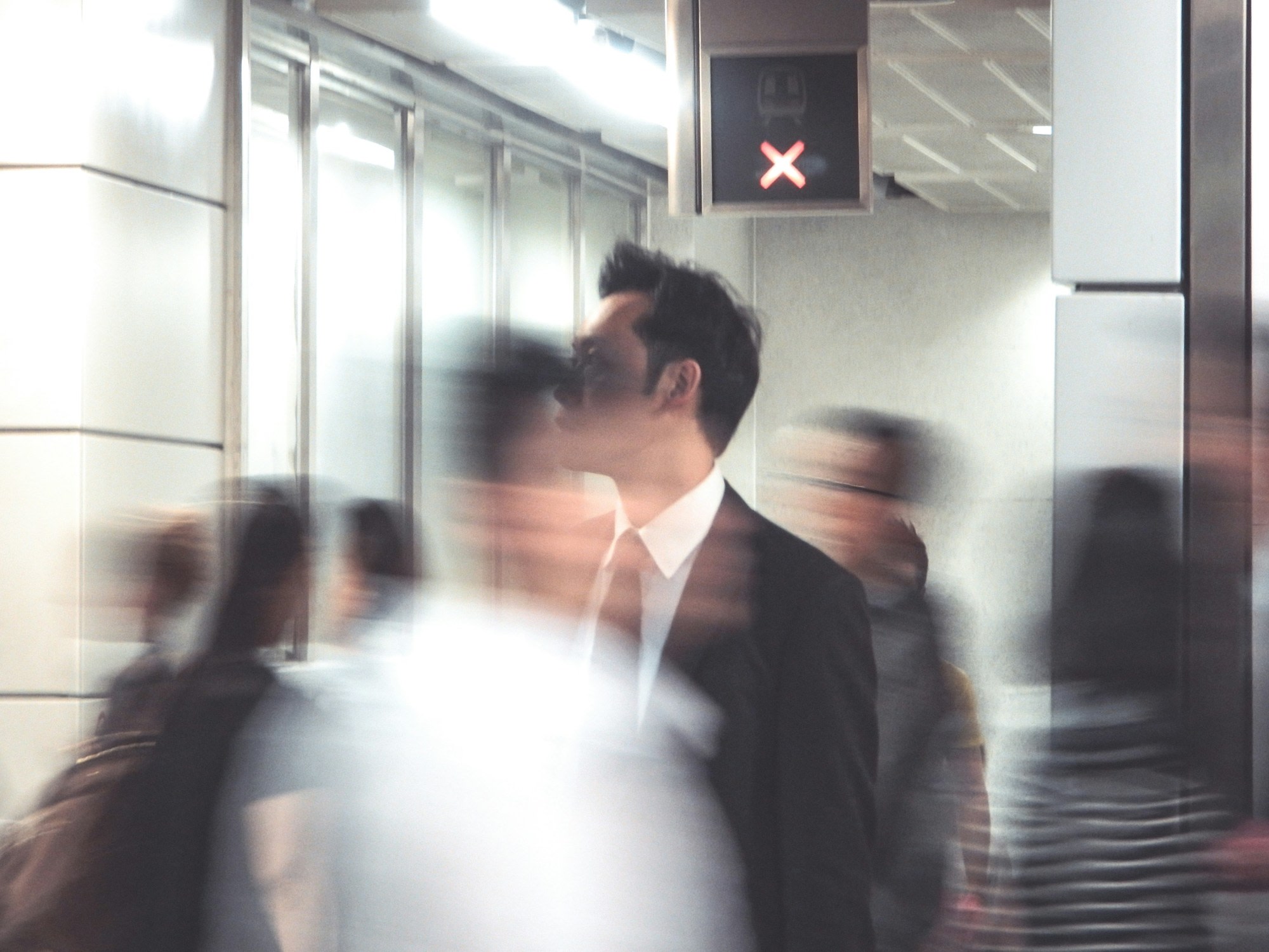 A blurry picture of a man in a suit in a crowded area