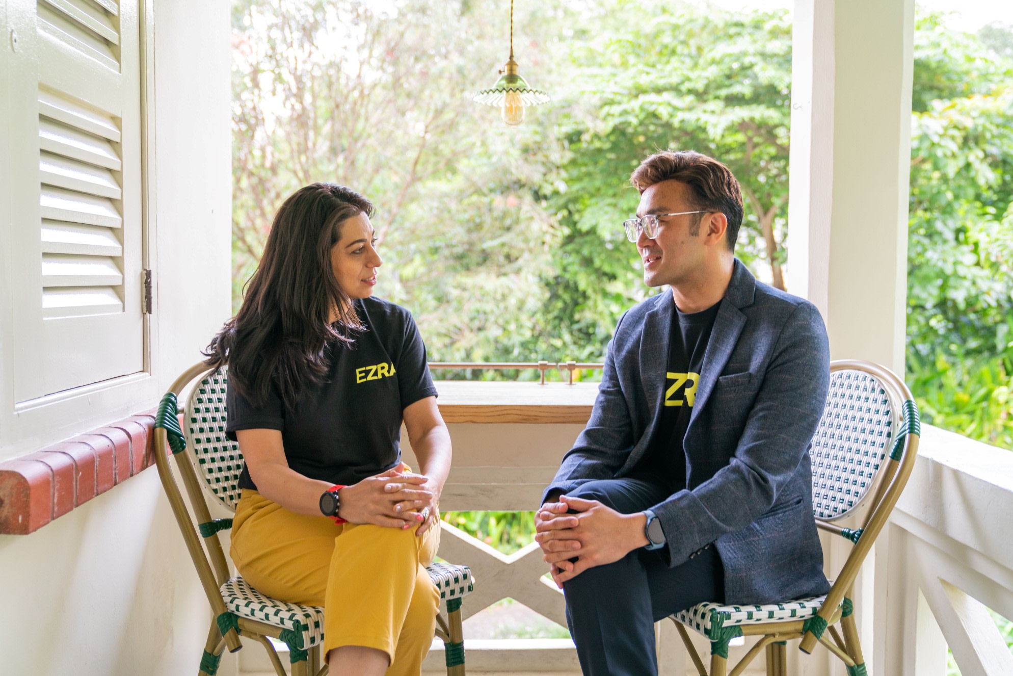 Two colleagues sat outside on chairs talking about leadership development.