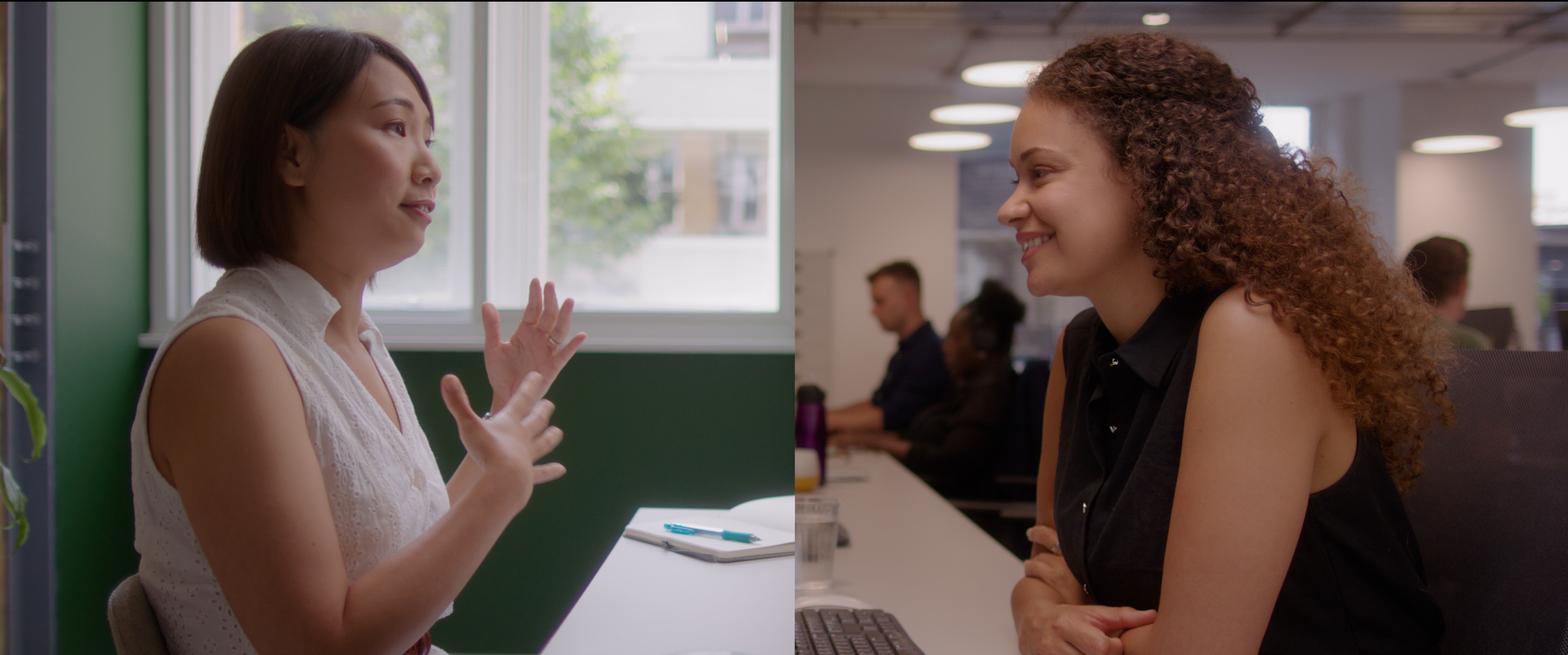 Video thumbnail, showing two women in conversation through virtual learning tech, one wearing a white top, the other a black top