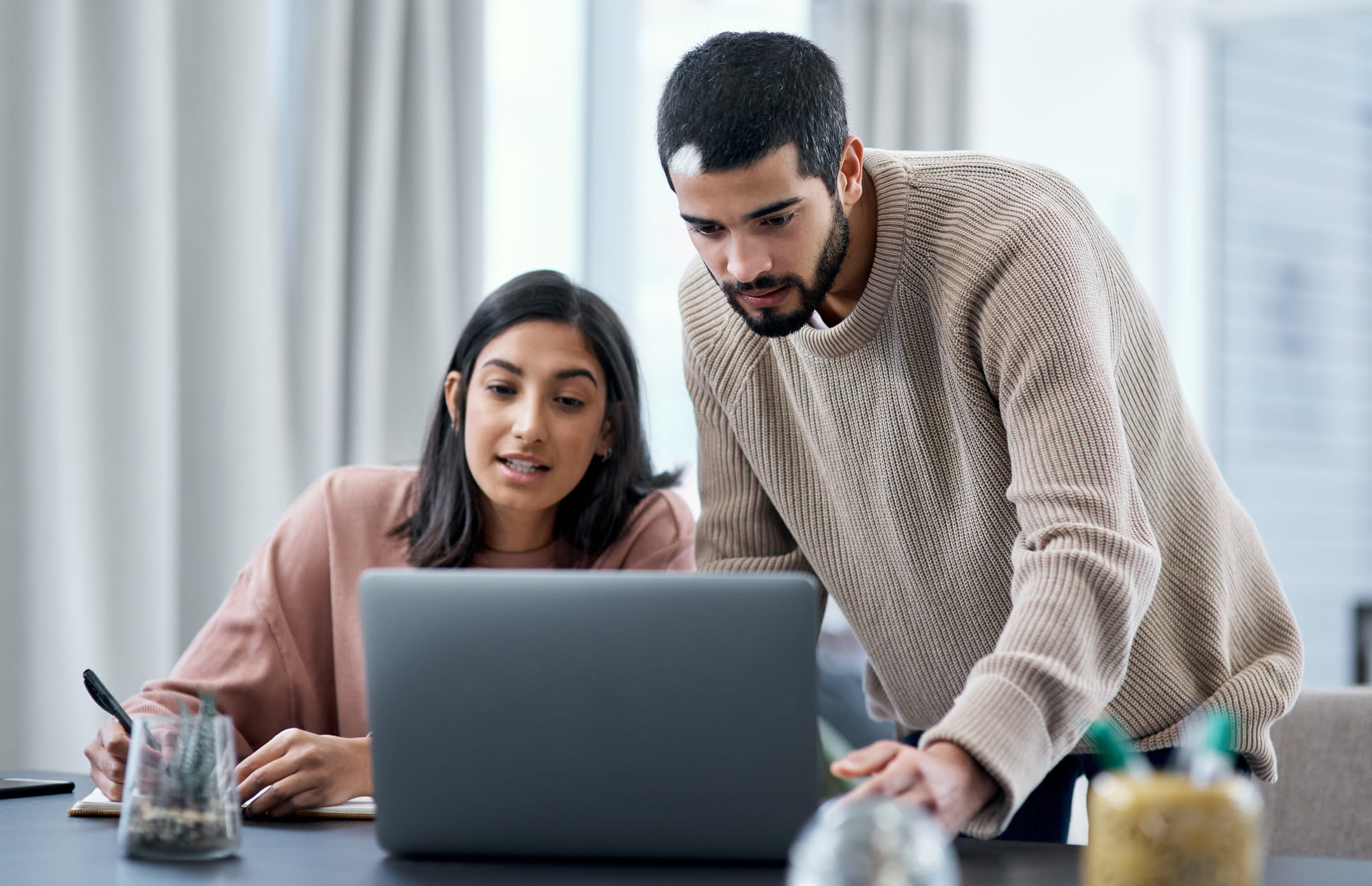 Shot of a young man and woman using a laptop while working from home