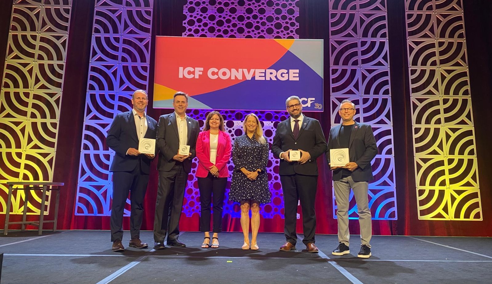Microsoft team on stage with EZRA at ICF Converge receiving the Coaching Impact Award