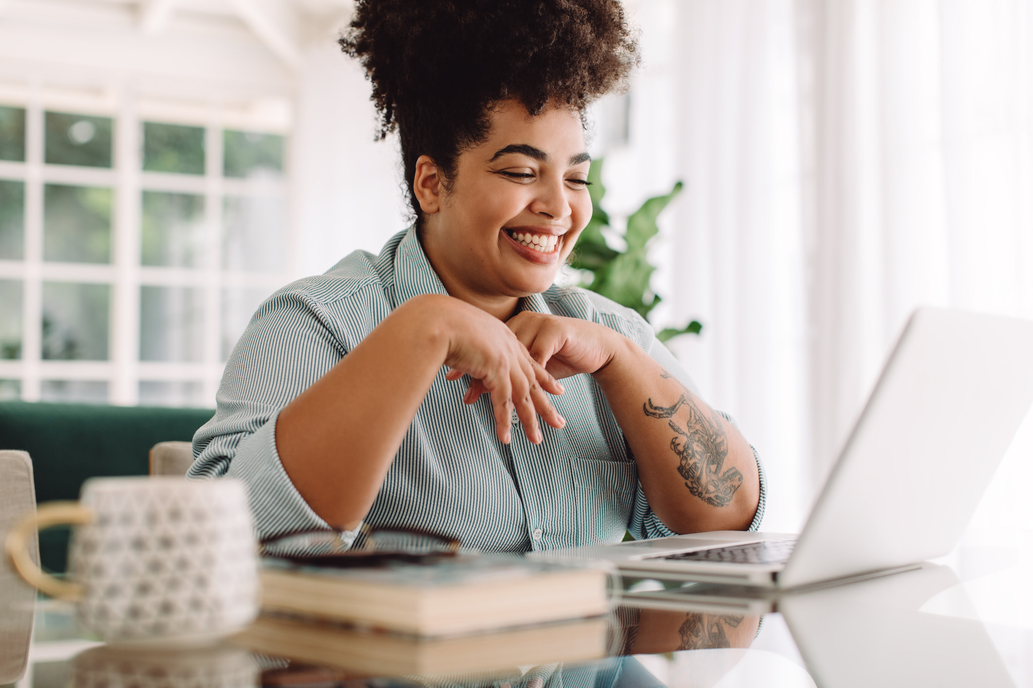 Woman smiling in front of laptop.