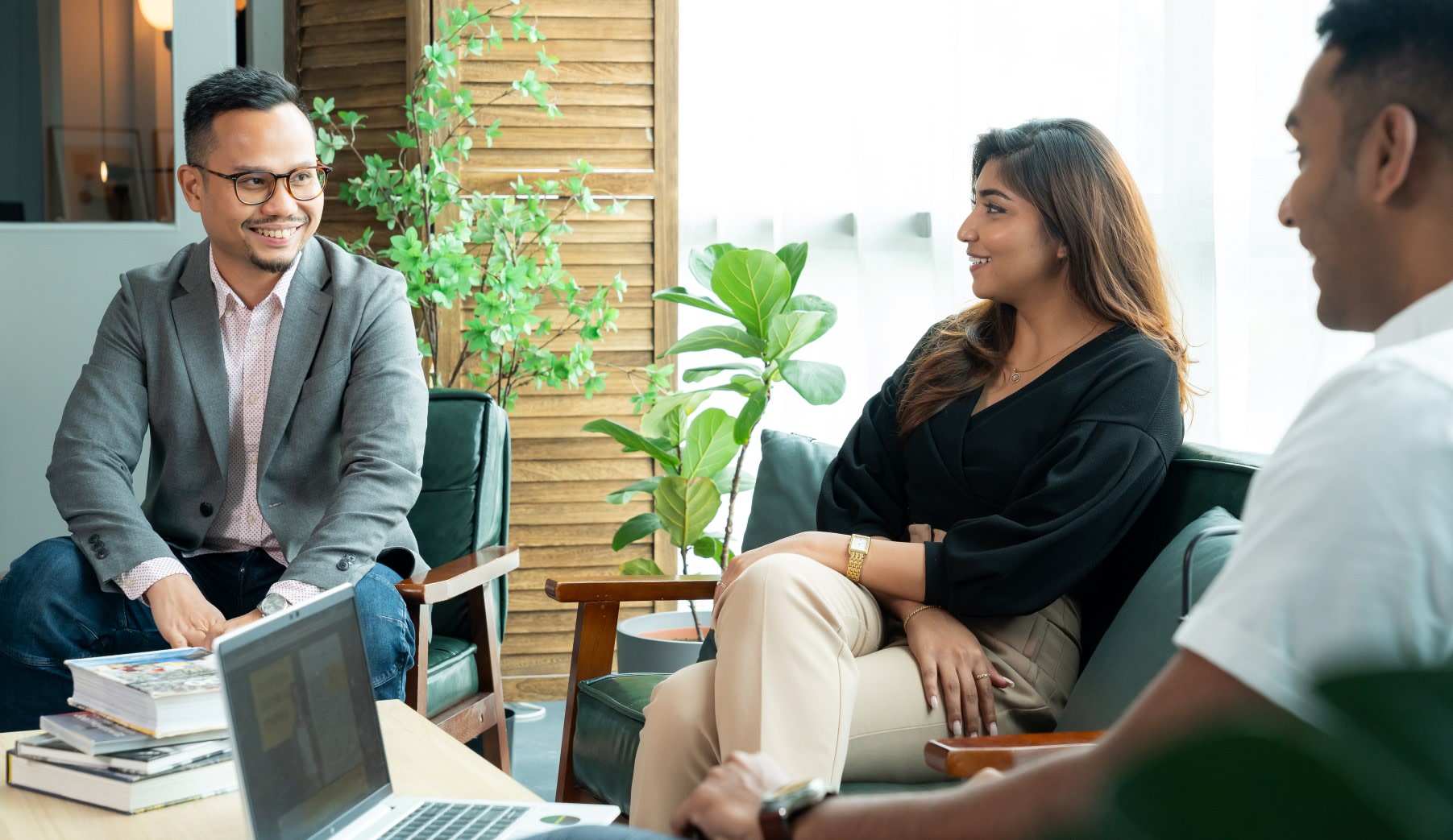Three colleagues sat together around a coffee table.
