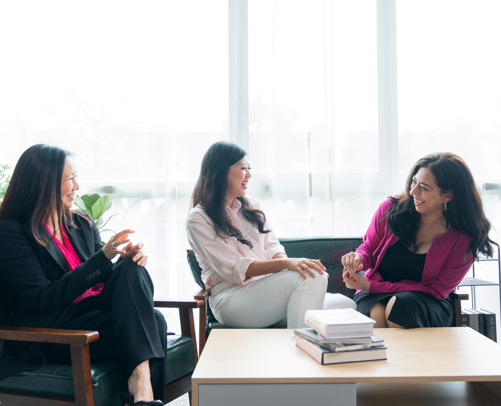 Due donne che ridono con il loro fornitore di formazione in coaching.