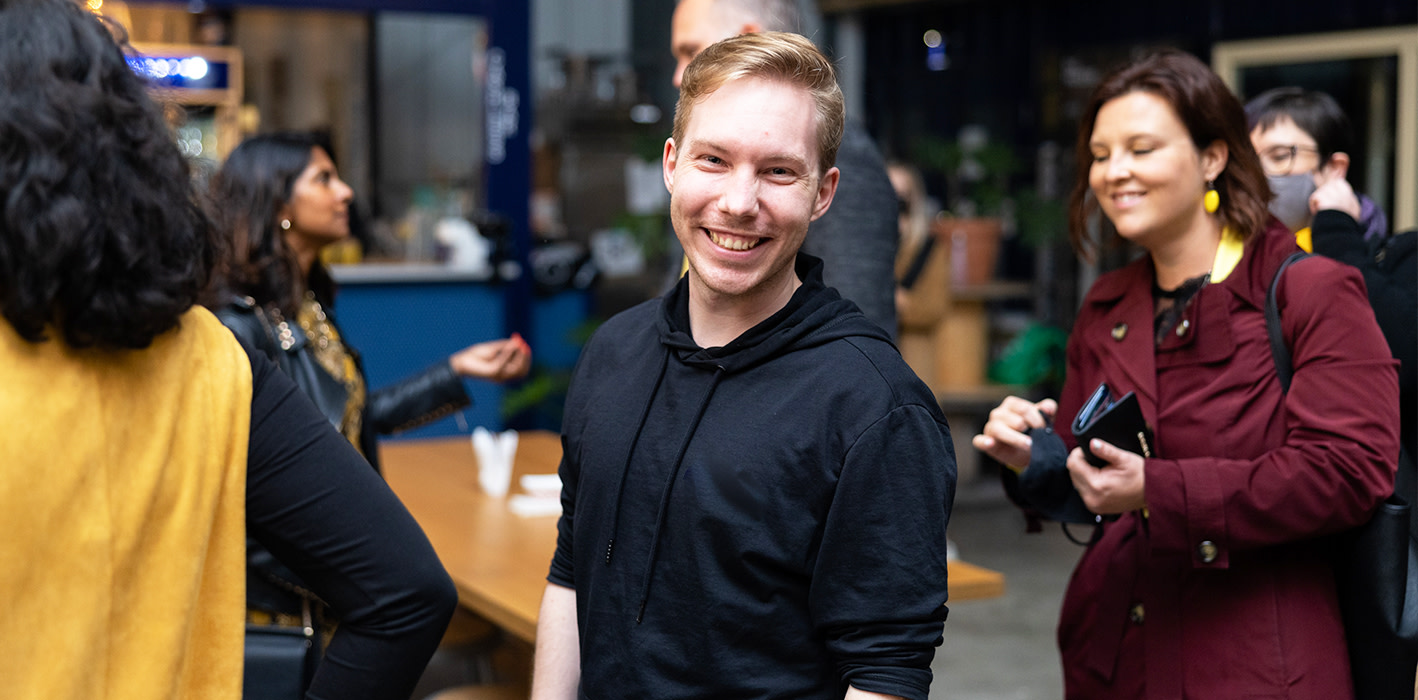 A young man smiling to the camera.