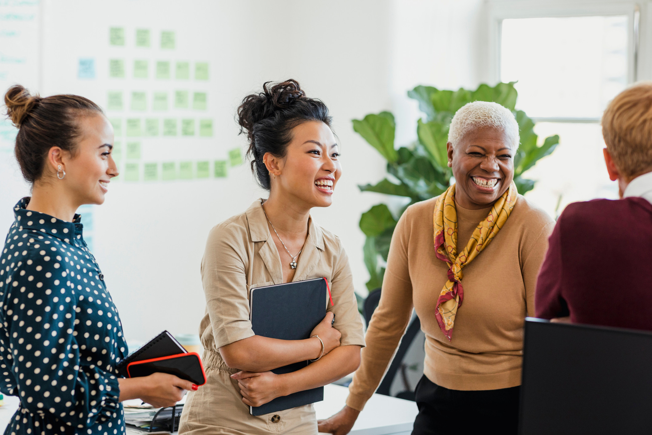A group of women laughing together at work.