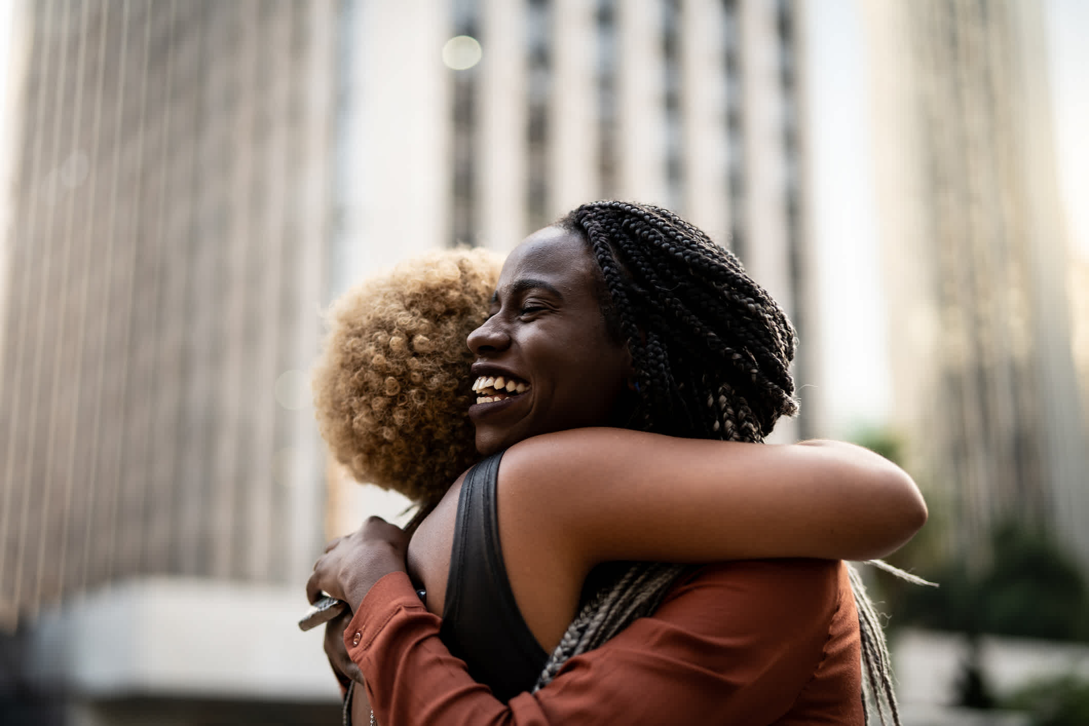 Two black women hugging and smiling. 