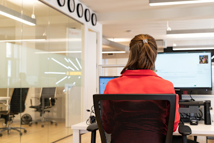 Woman sat working at her desk in an office space.