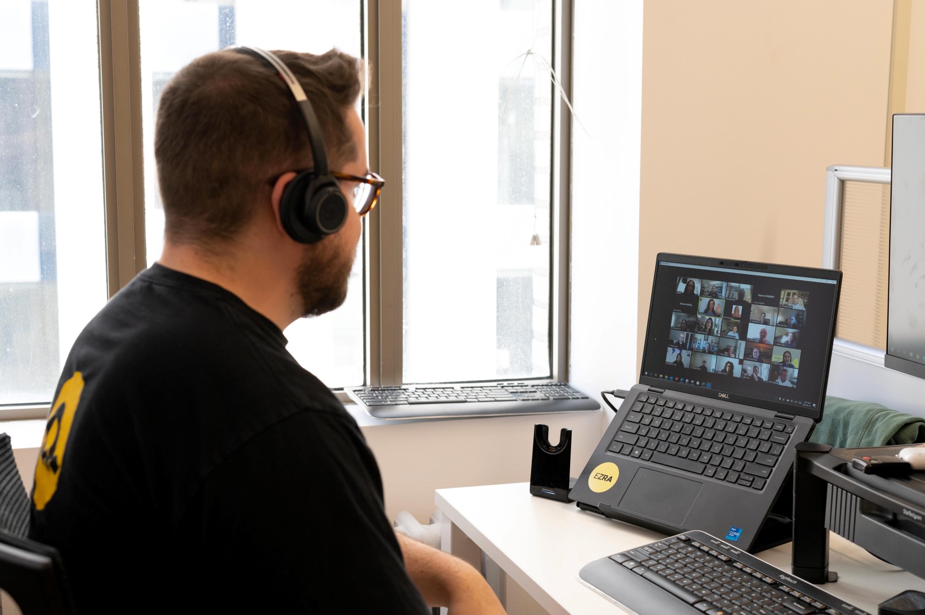 Side profile of man with glasses and headphones on a virtual call