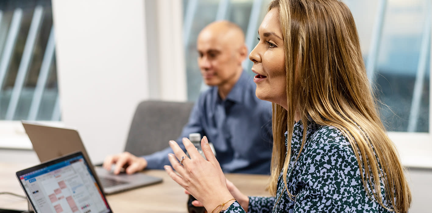 Lady with brown hair, wearing black and white top, delivering strategic leader coaching