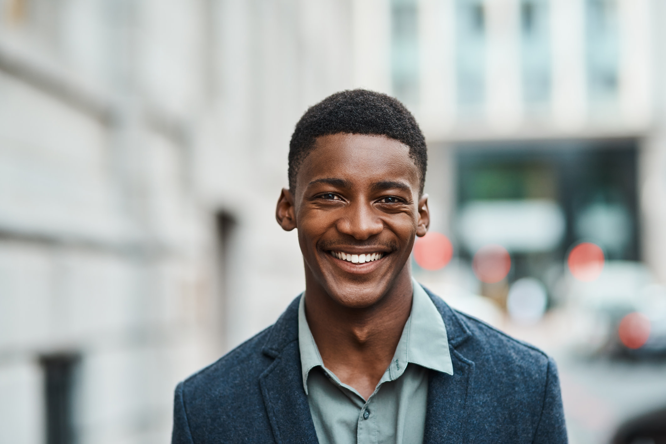 Portrait of a confident young businessman standing against an urban background

