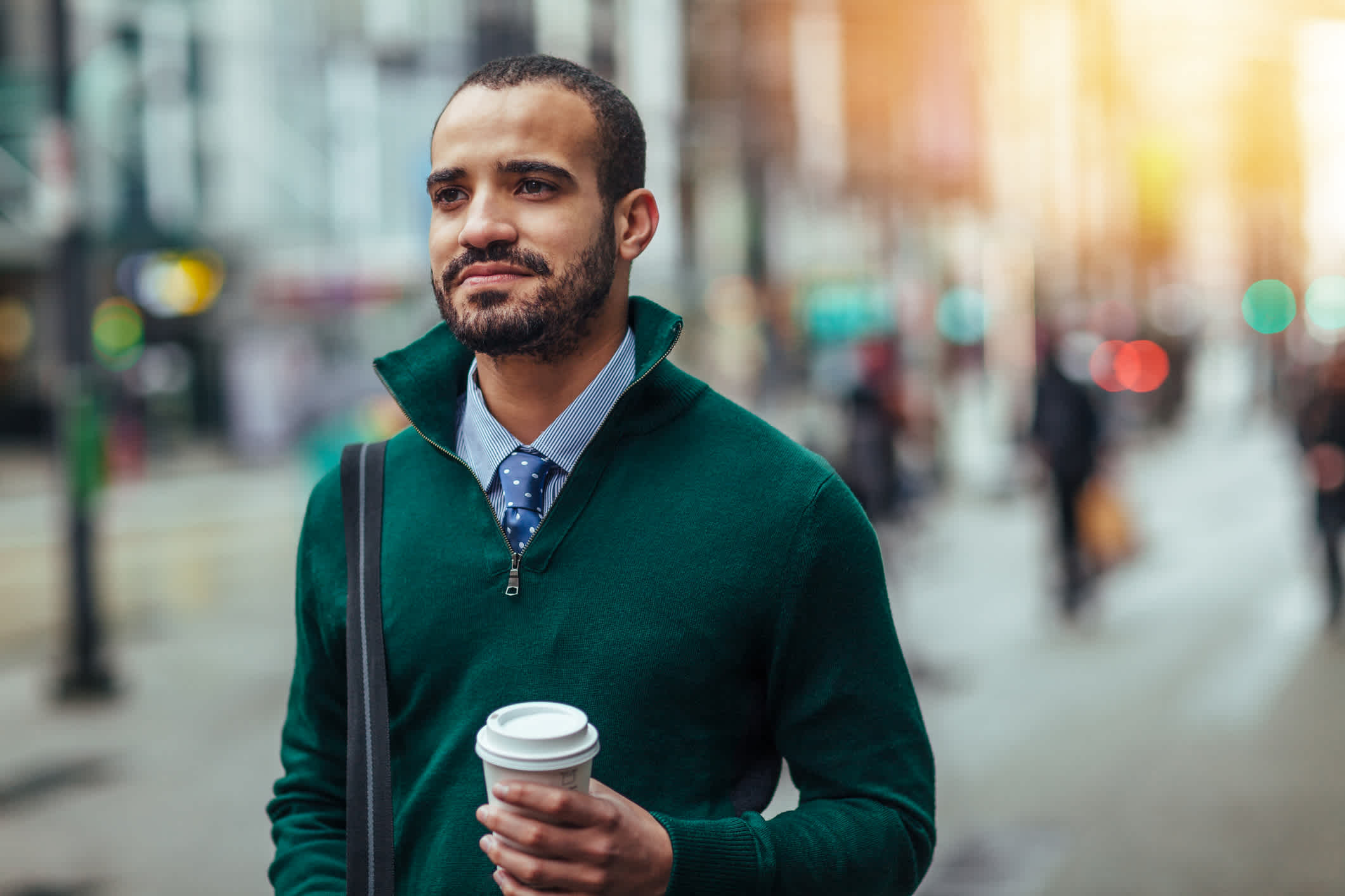 Street portrait of a young businessman holding a cup of coffee 