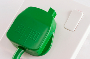 Image of a green plug being plugged into a socket. 