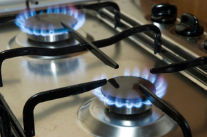 Image of two stove tops with their flames on.