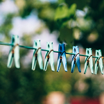 Image of pegs on washing line on sunny day in garden.