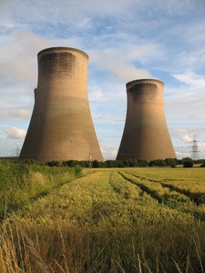 Image of two nuclear power plants behind a large field.