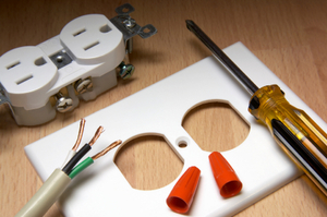 Image of a disassembled wall socket with tools to fix it.