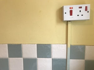 Power switch plug socket on a yellow wall.