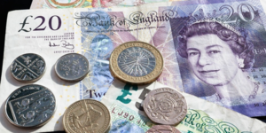 Image of British twenty pound note and six coins.