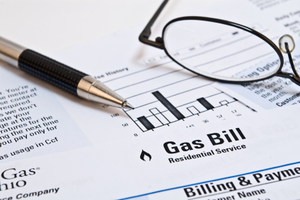 Image of a gas bill with pen and glasses on top of it.