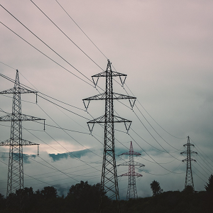 four electricity pylons with cloudy sky in background