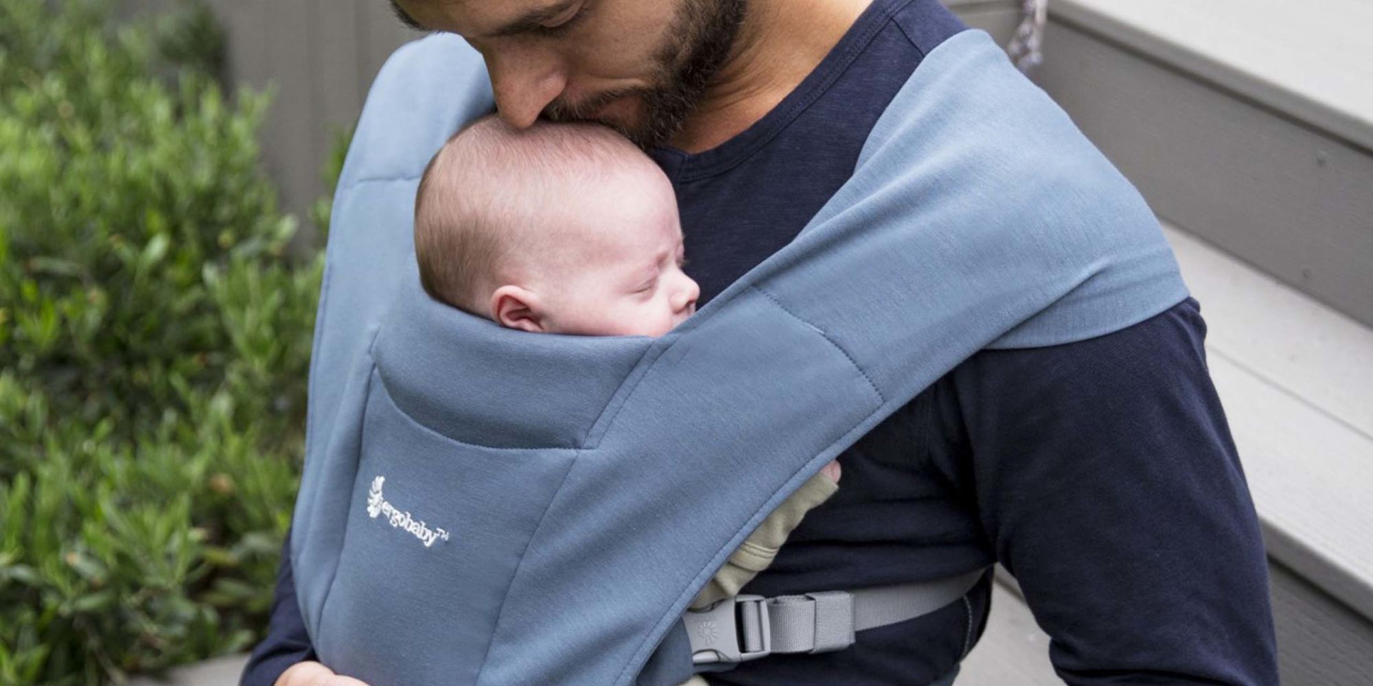 man carrying a baby in a sling