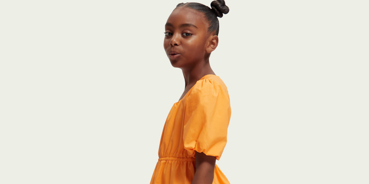 Girl wearing an orange Scotch&Soda dress