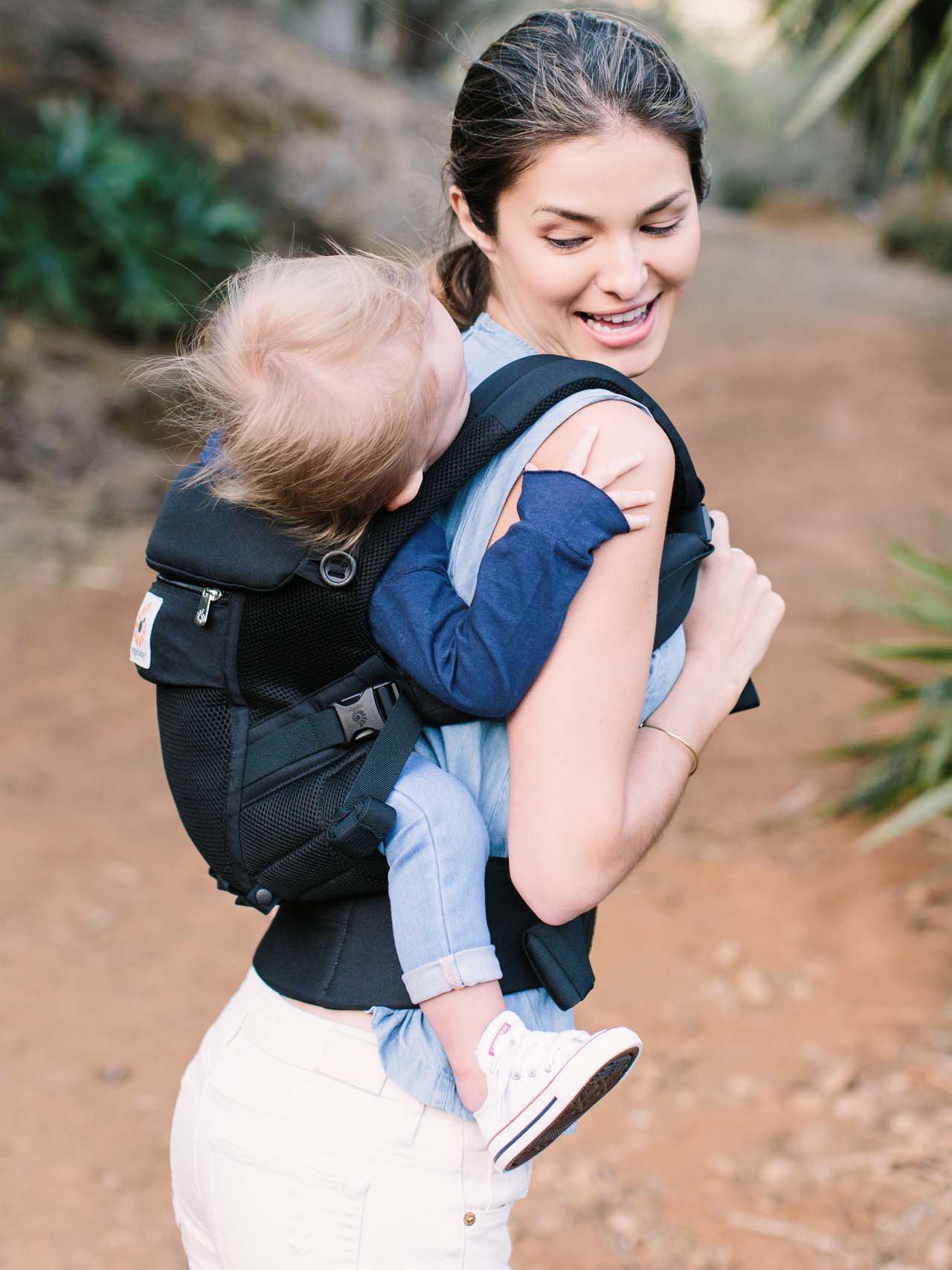 woman carrying a baby in an Ergobaby baby carrier