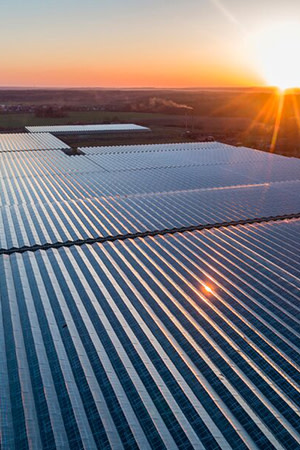 an aerial view of greenhouse structures with a sunset - Lumiforte supplied