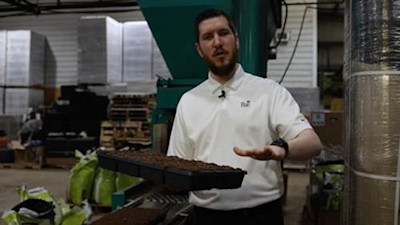Nick Flax holds a filled soil tray