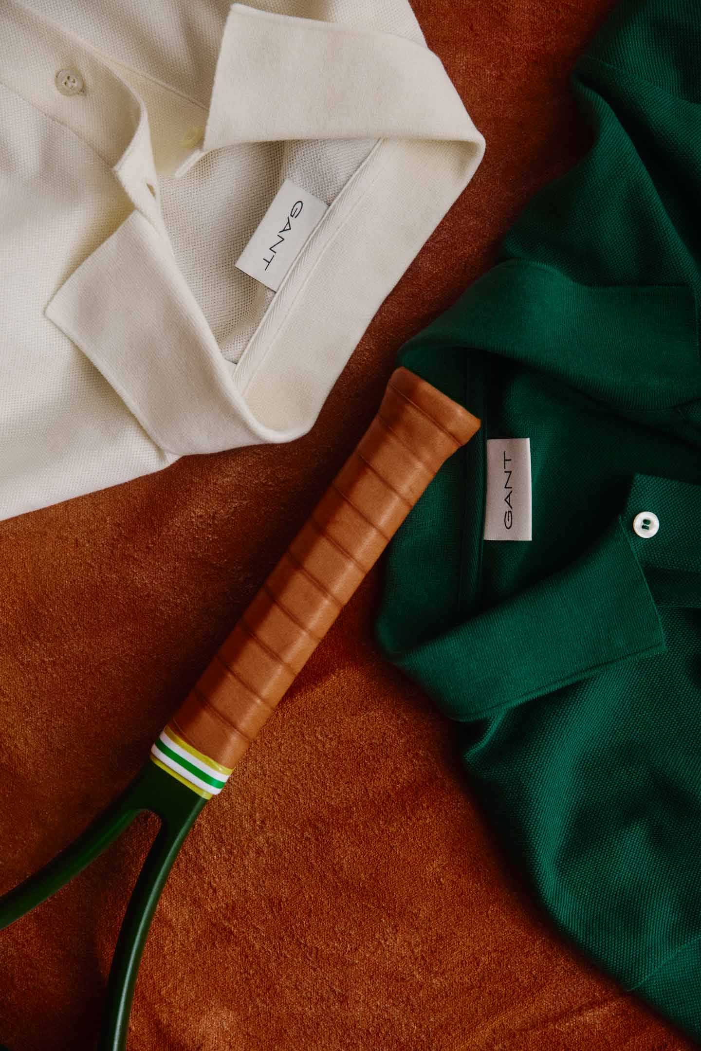 Tennis merchandise featuring white and green polo shirts with a tennis racket.