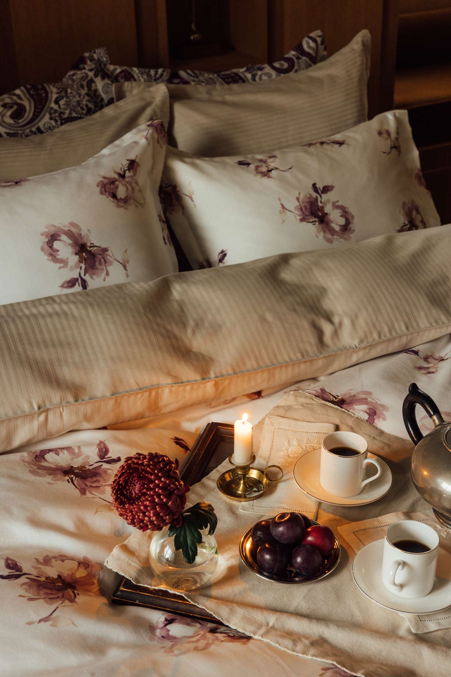 Gant floral bedding styled with a breakfast tray, coffee cups and flowers on a bed.