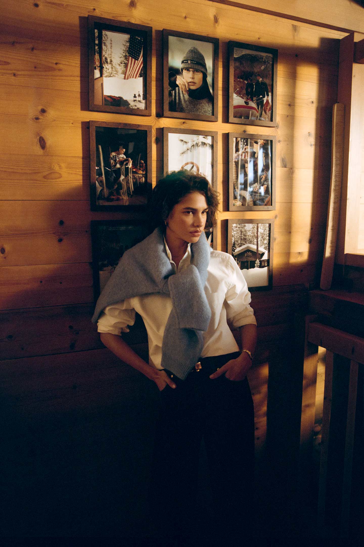 Model styled with a Gant button-down shirt paired with tailored pants and a knit sweater draped over the shoulders.