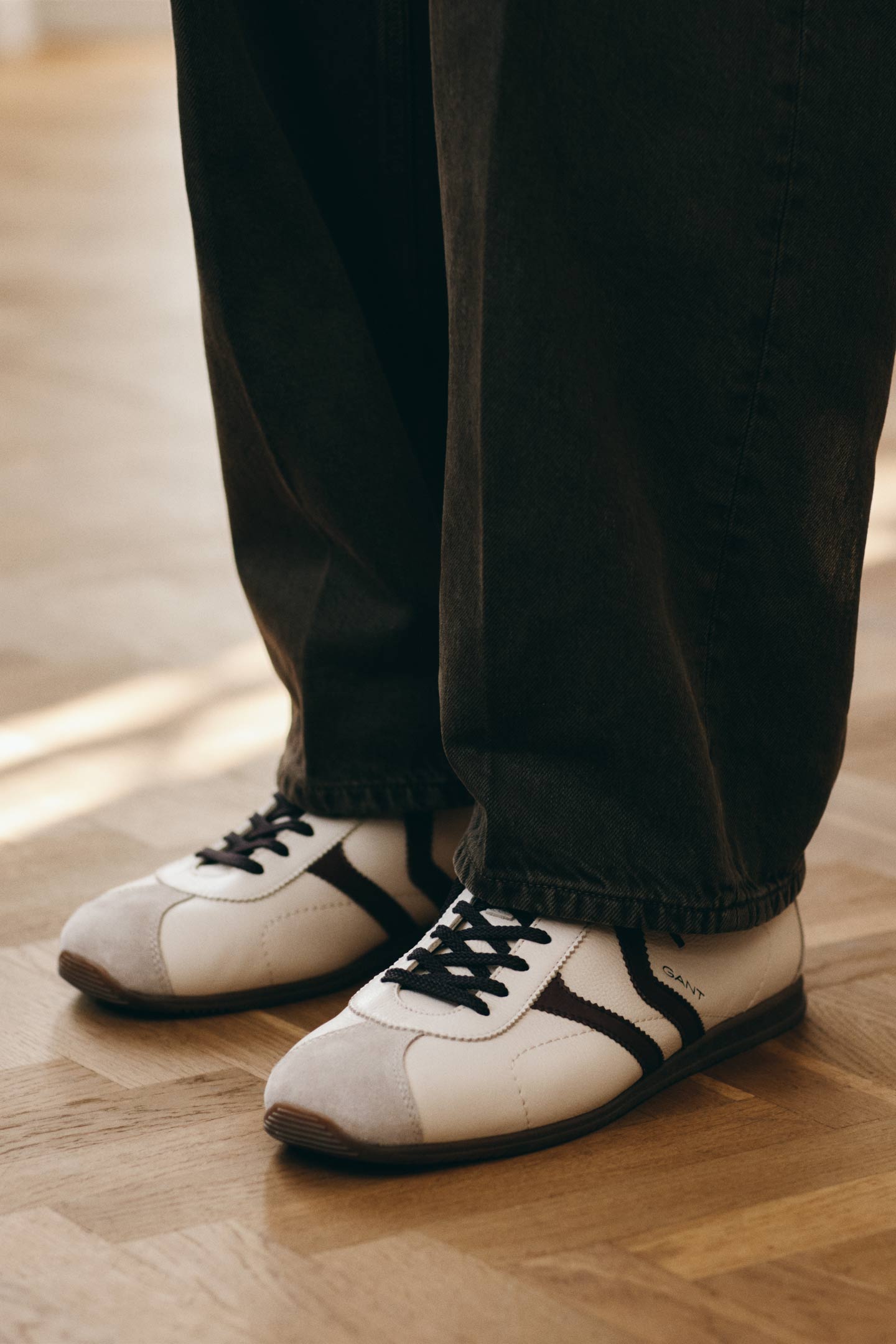 Gant leather sneakers paired with dark-wash jeans, shown in a close-up footwear detail.