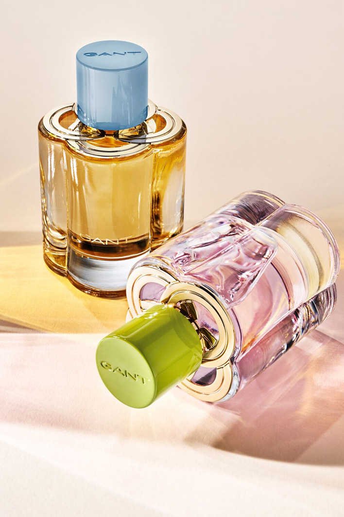 Deux flacons de parfum GANT pour femme aux tons ambrés et roses, présentés sur un fond clair et doux