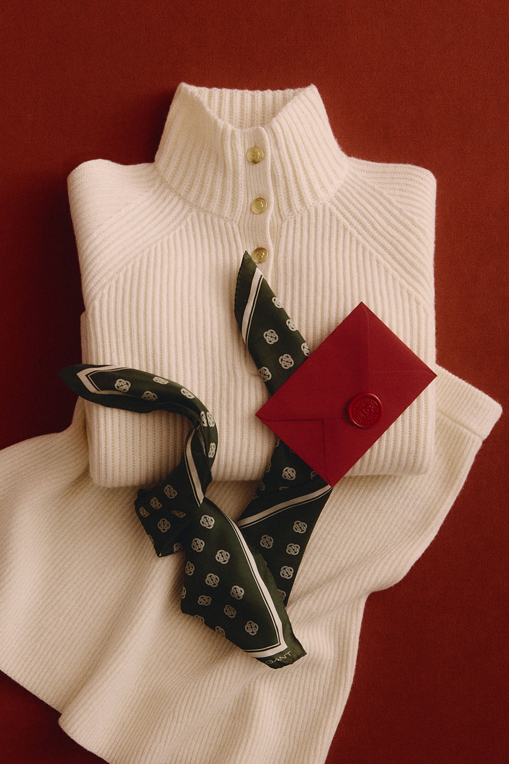 Cream rib-knit sweater paired with a matching rib-knit skirt and a patterned silk scarf.