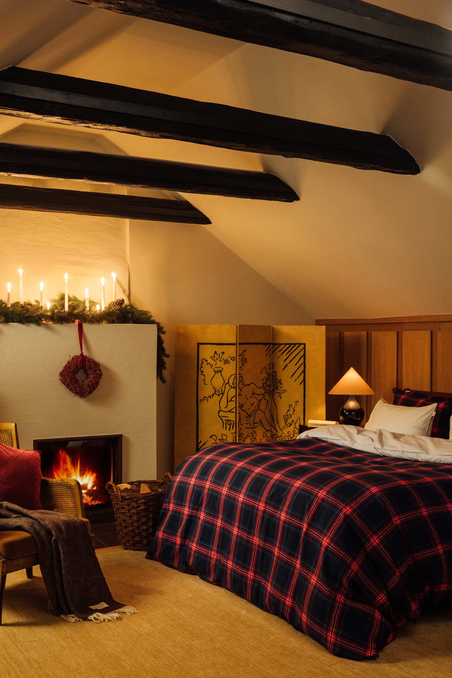 Gant checked duvet cover styled on a bed beside a fireplace in a cosy bedroom interior.