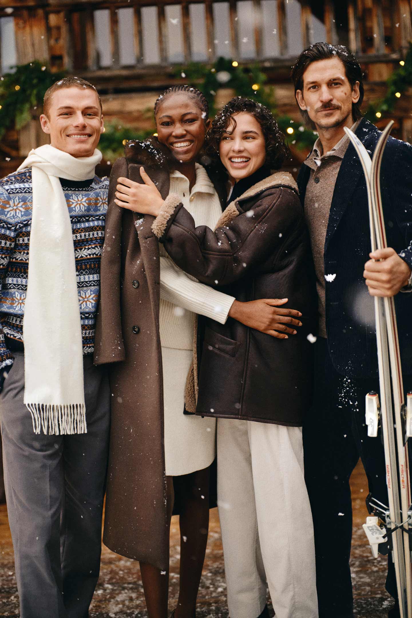 Four models in a snowy outdoor setting wearing Gant Fair Isle knit sweater with tailored pants and a wool scarf; Gant wool coat over a ribbed knit dress and Gant shearling jacket with light-coloured pants.