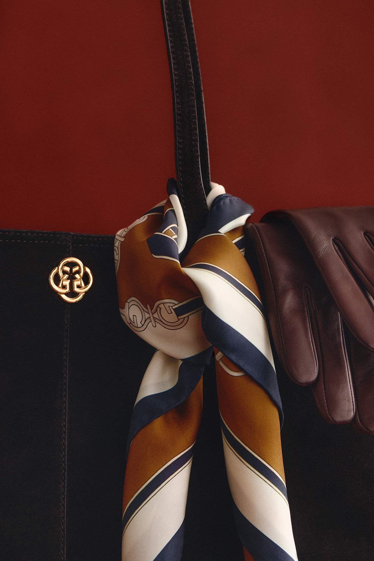 Dark brown Gant leather tote bag styled with a patterned silk scarf and brown leather gloves.
