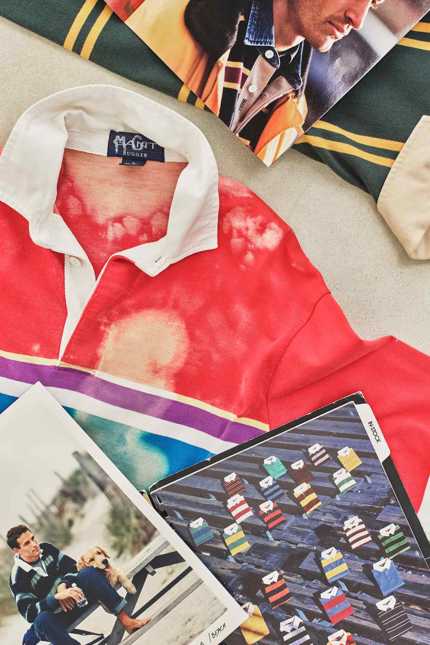Camicia da rugby vintage Gant e immagini di catalogo esposte su una superficie piana.