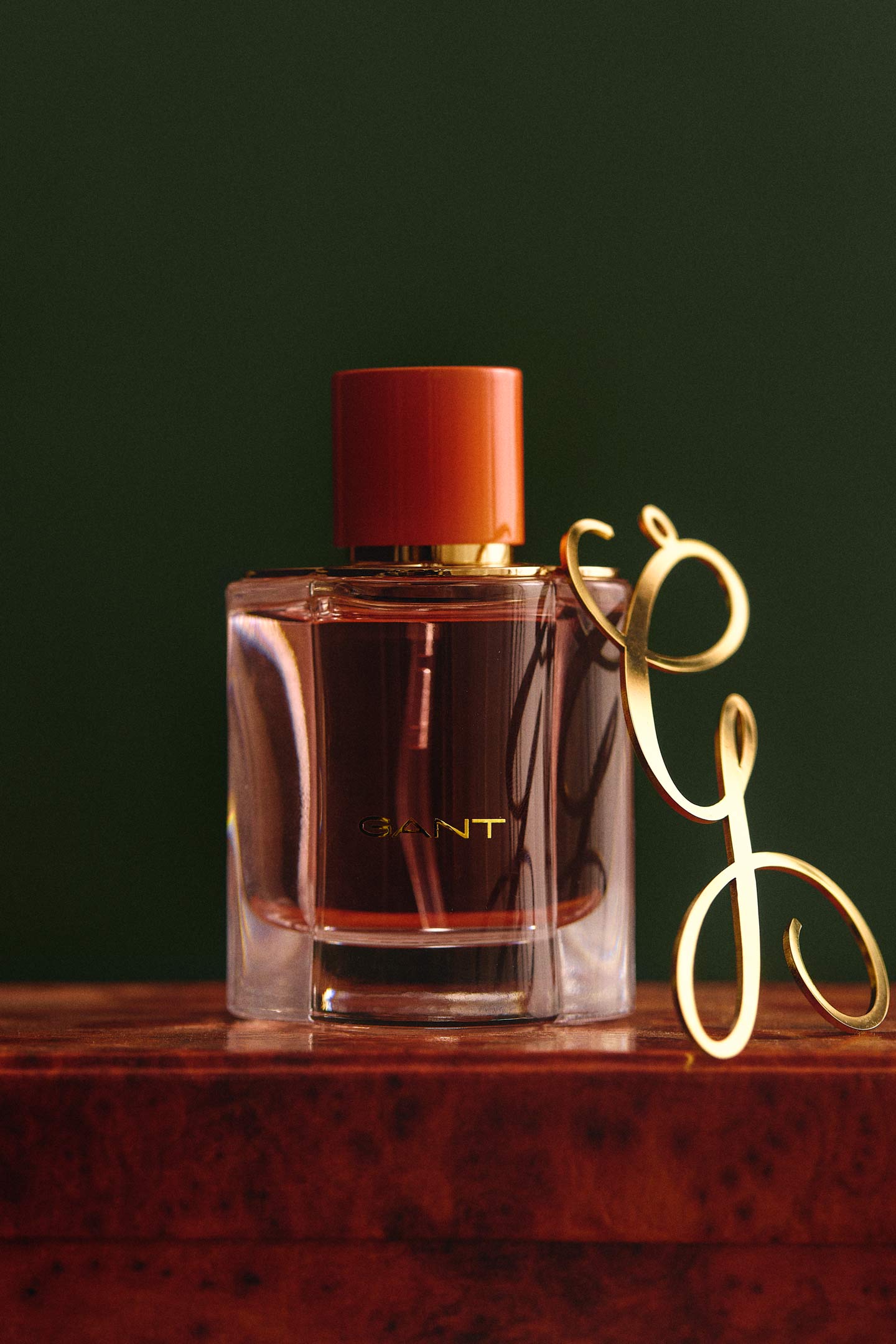 Gant fragrance bottle with a red cap and transparent glass design.