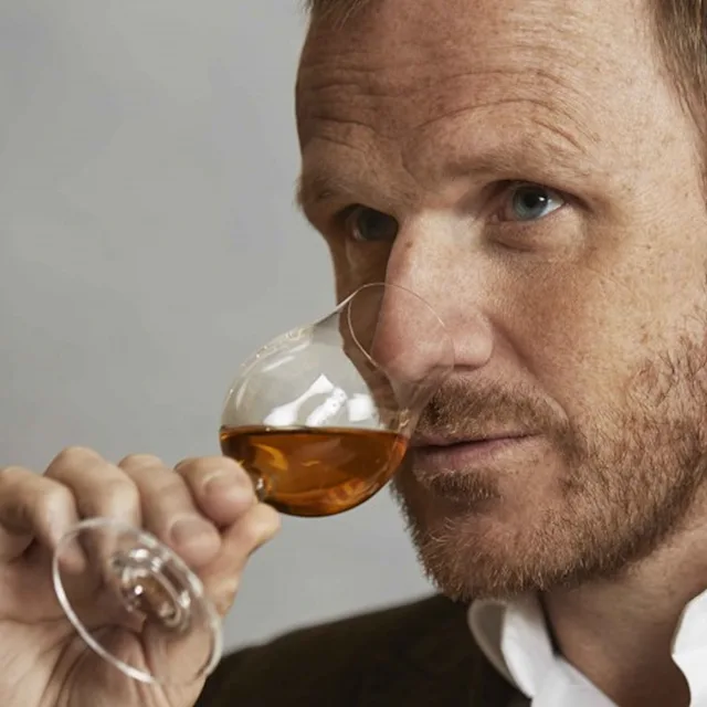 Een man die voorzichtig aan een glas whisky zit te nossen, wat staat voor het vakmanschap achter The Singleton Gourmand Collection.