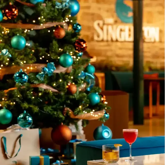 Singleton Cocktail beside lit christmas tree