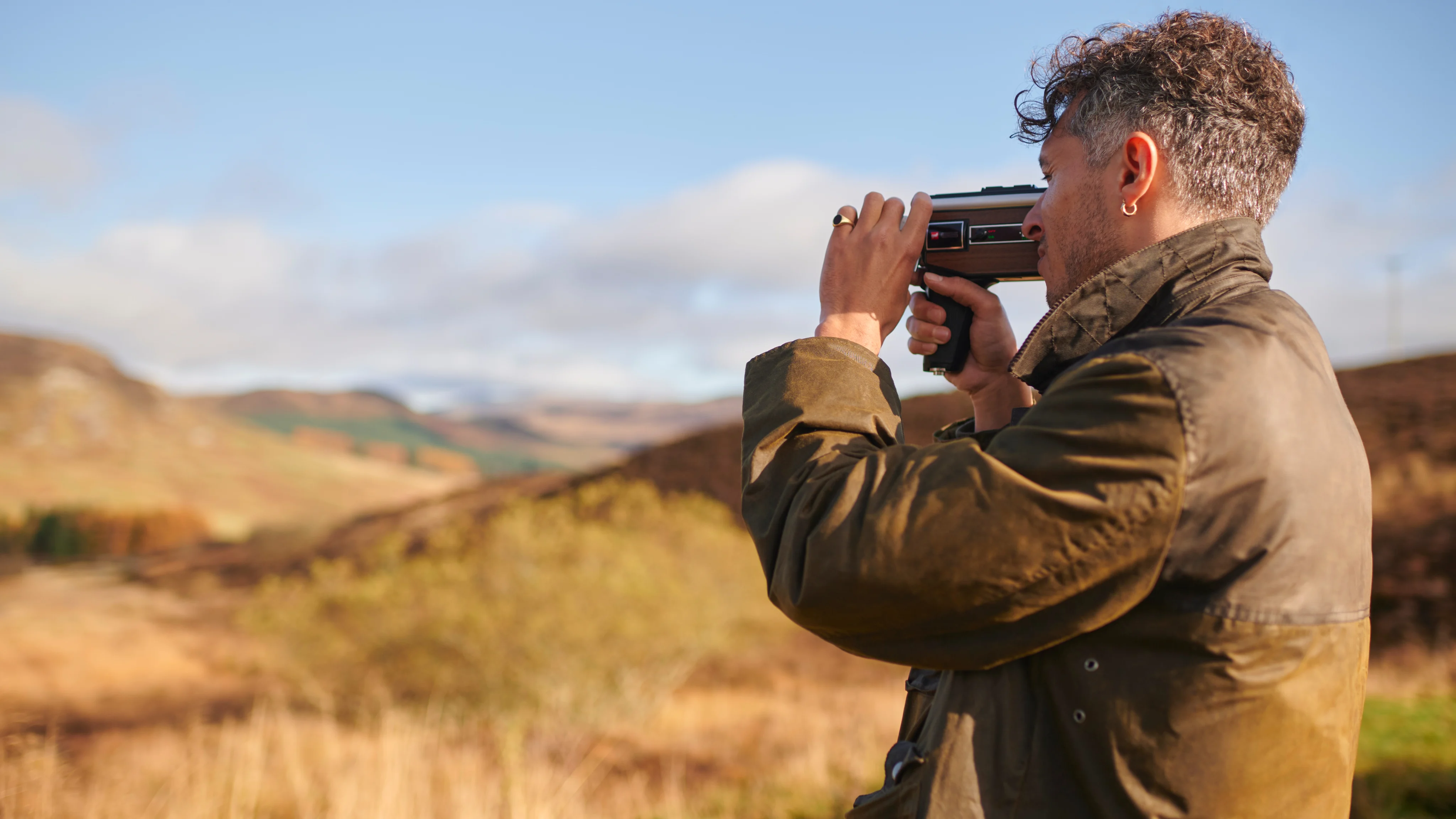 Man filming the countryside in Scotland.