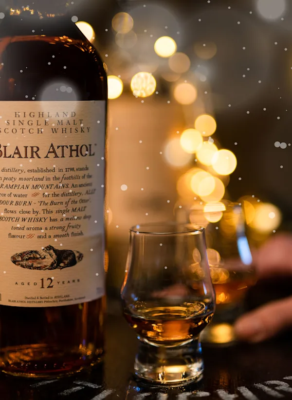 Bottle of Blair Athol Whisky, and two small glasses of whisky during Christmas